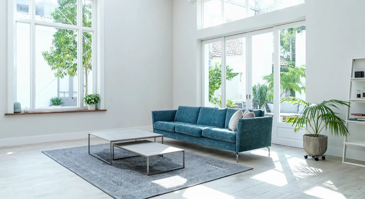 Helles Wohnzimmer mit Sofa und großen Fenstern