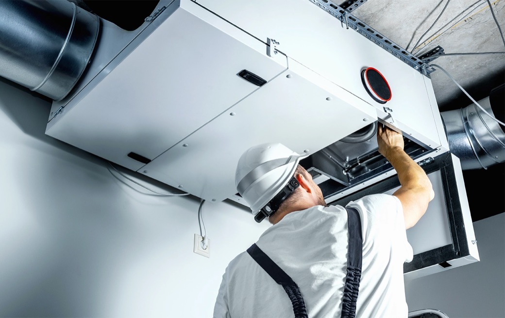 Techniker bei der Optimierung einer Lüftungsanlage an der Decke